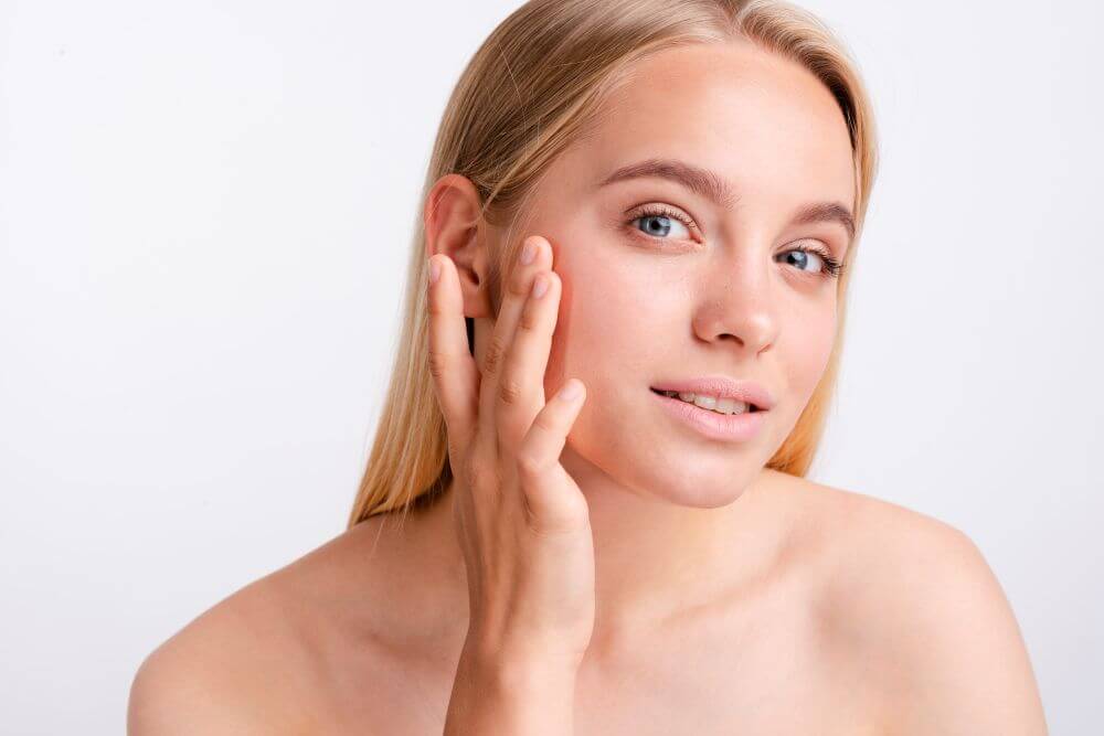 Photo of a woman rubbing her face with a white background