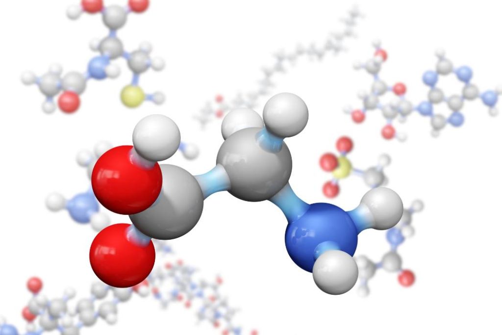 A 3D ball-and-stick model of the amino acid Glycine prominently displayed in the foreground. The molecule features standard CPK coloring: grey spheres for carbon, white for hydrogen, red for oxygen, and blue for nitrogen. It is set against a white background containing several other blurred, out-of-focus molecular structures.